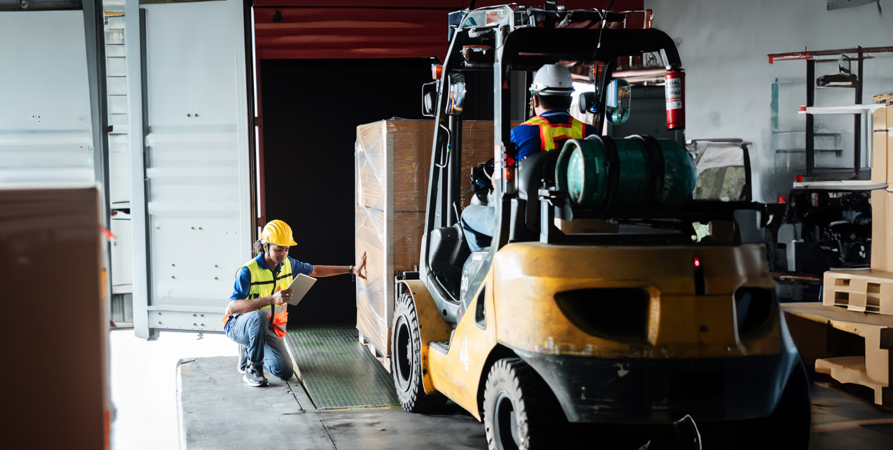 forklift loading cargo onto straight truck featured