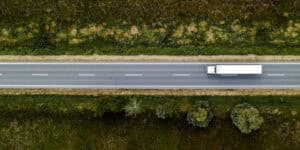 truck on highway with trees on both sides
