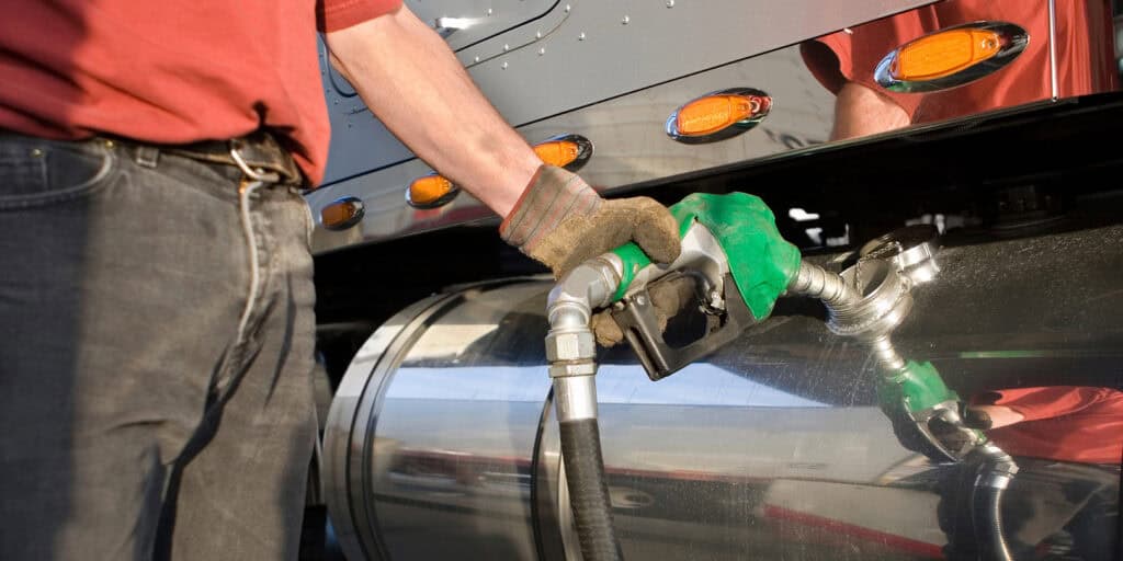 truck driver filling a gas tank with fuel