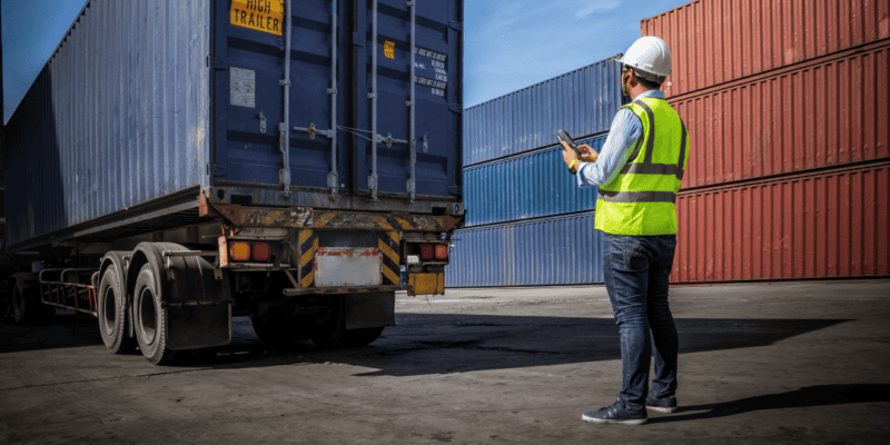 person inspecting a drayage truckload