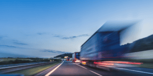 trucks driving on highway - blurry image with morning sky