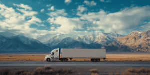 freight truck driving on highway near mountains